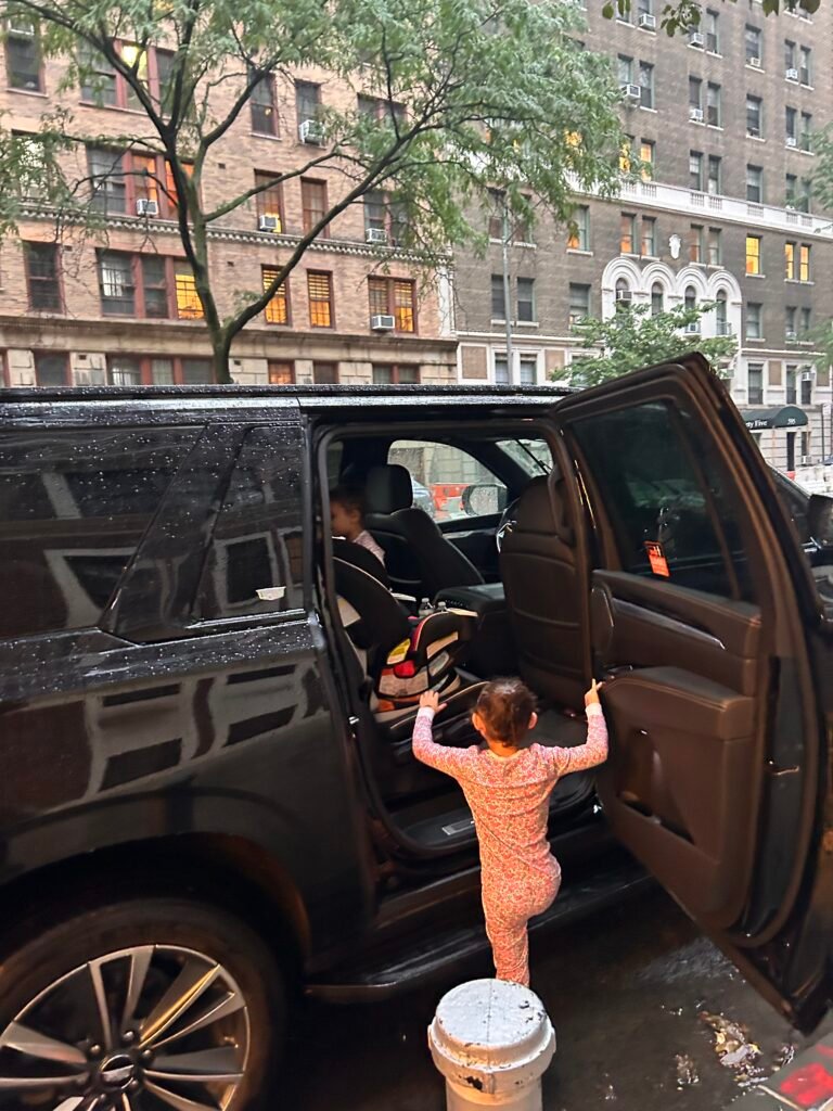 Child getting into a Ride in Style SUV equipped with car seats for an NYC airport transfer