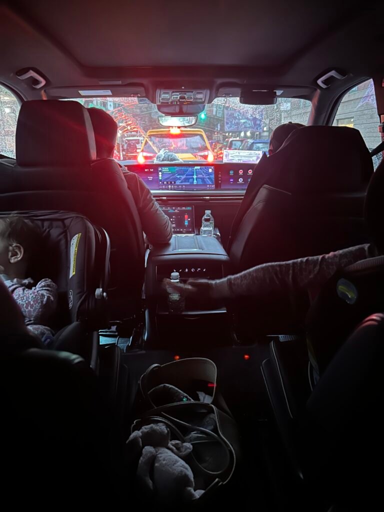 Family riding to the airport in New York City with children secured in car seats