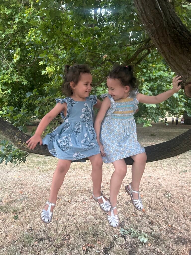 Girls sitting on a tree in Hyde Park, London