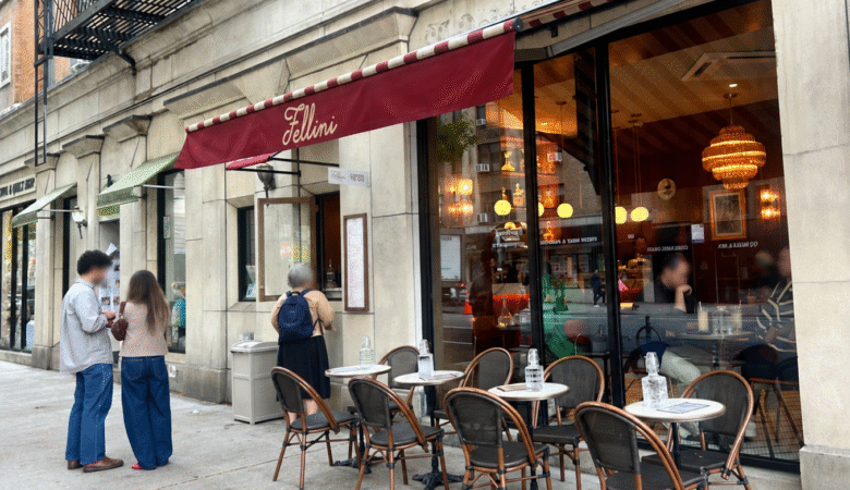 Fellini Coffee on the Upper West Side of Manhattan, with a burgundy awning, outdoor café seating, and people along the sidewalk.